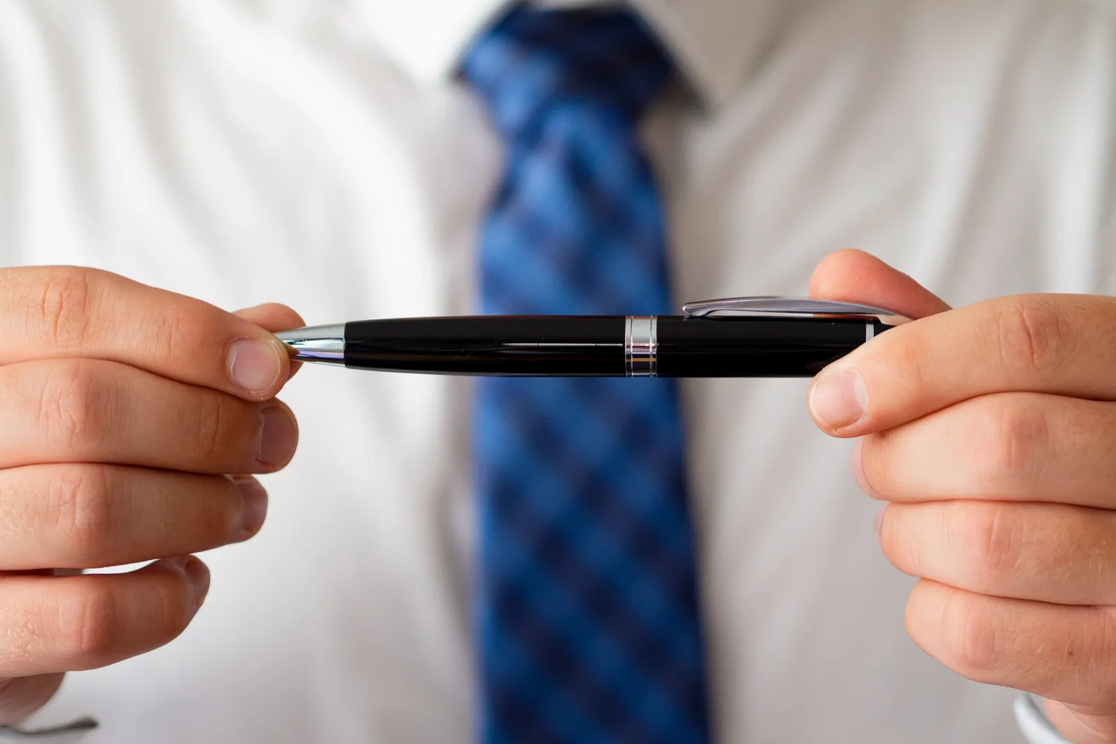 Des stylos personnalisés sont disposés sur un bureau de travail avec un prototype examiné à la lumière du jour.