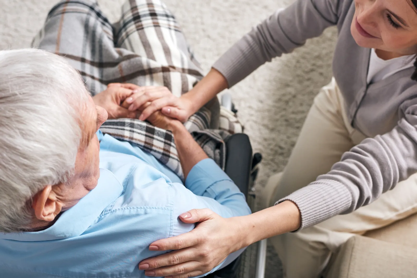 Un couple de seniors consulte des documents de mutuelle et des factures de santé à la table de la cuisine.